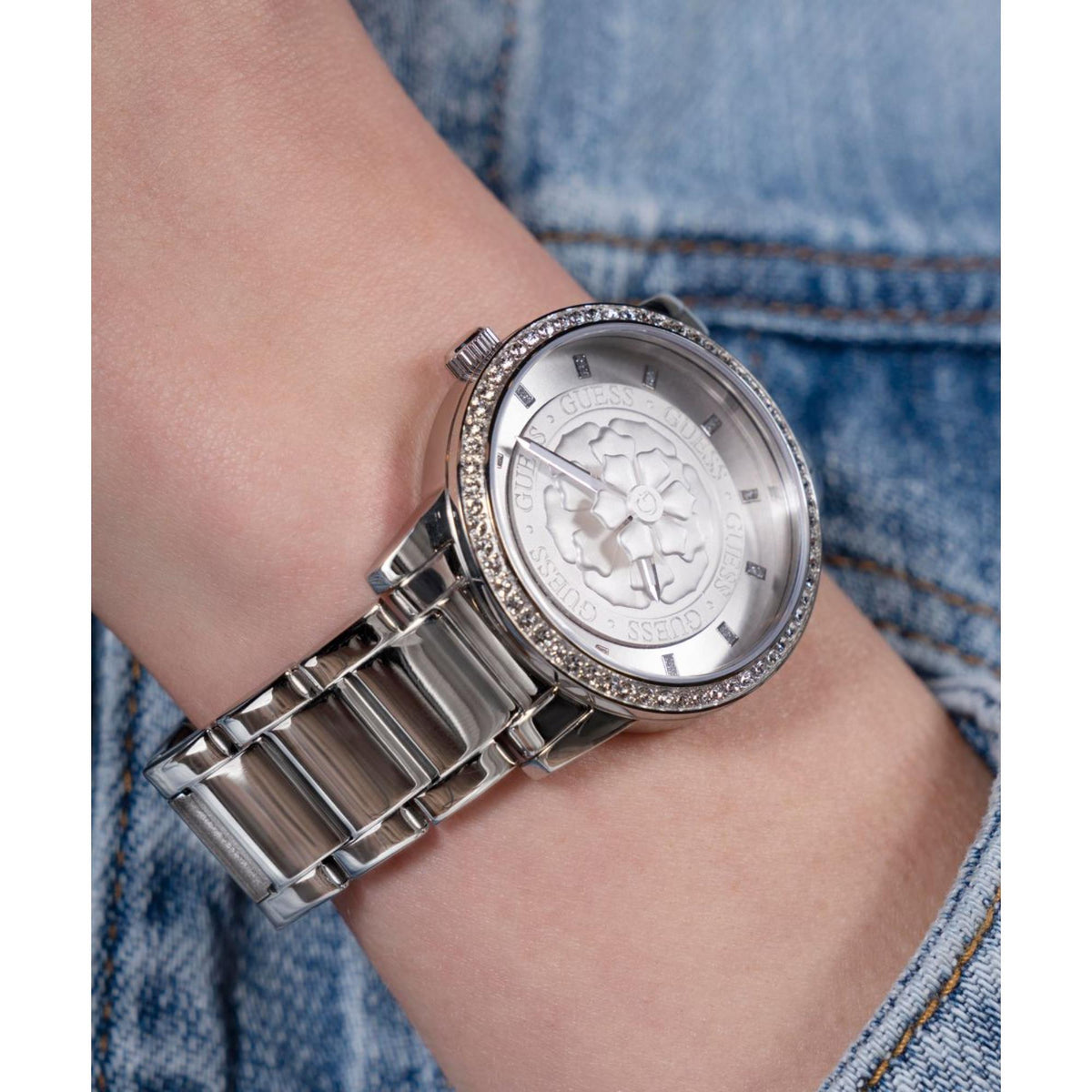 Women’s silver-tone watch on wrist, close-up of gray textured dial and crystal rim