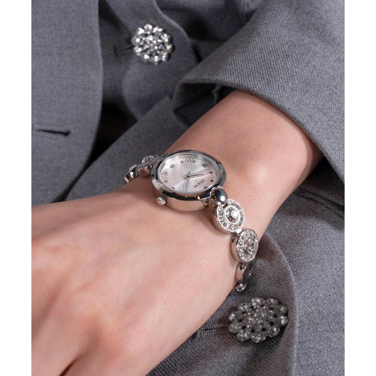 Women’s silver-tone bracelet watch with round gray dial and crystal links on wrist