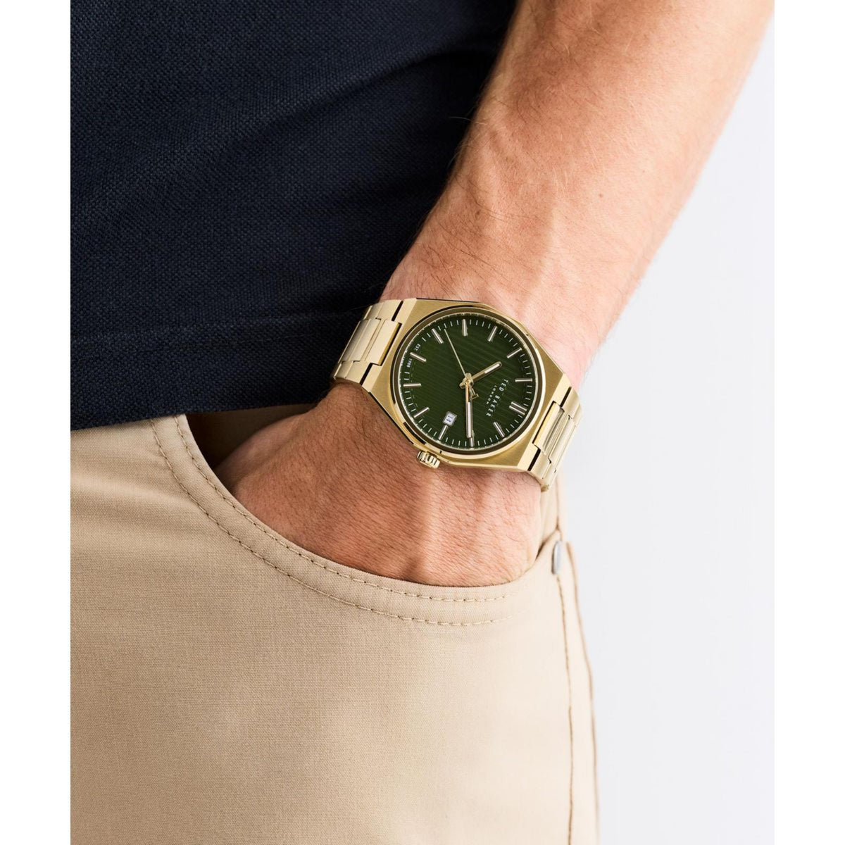 Men's Ted Baker watch on wrist with green dial and gold-tone metal band