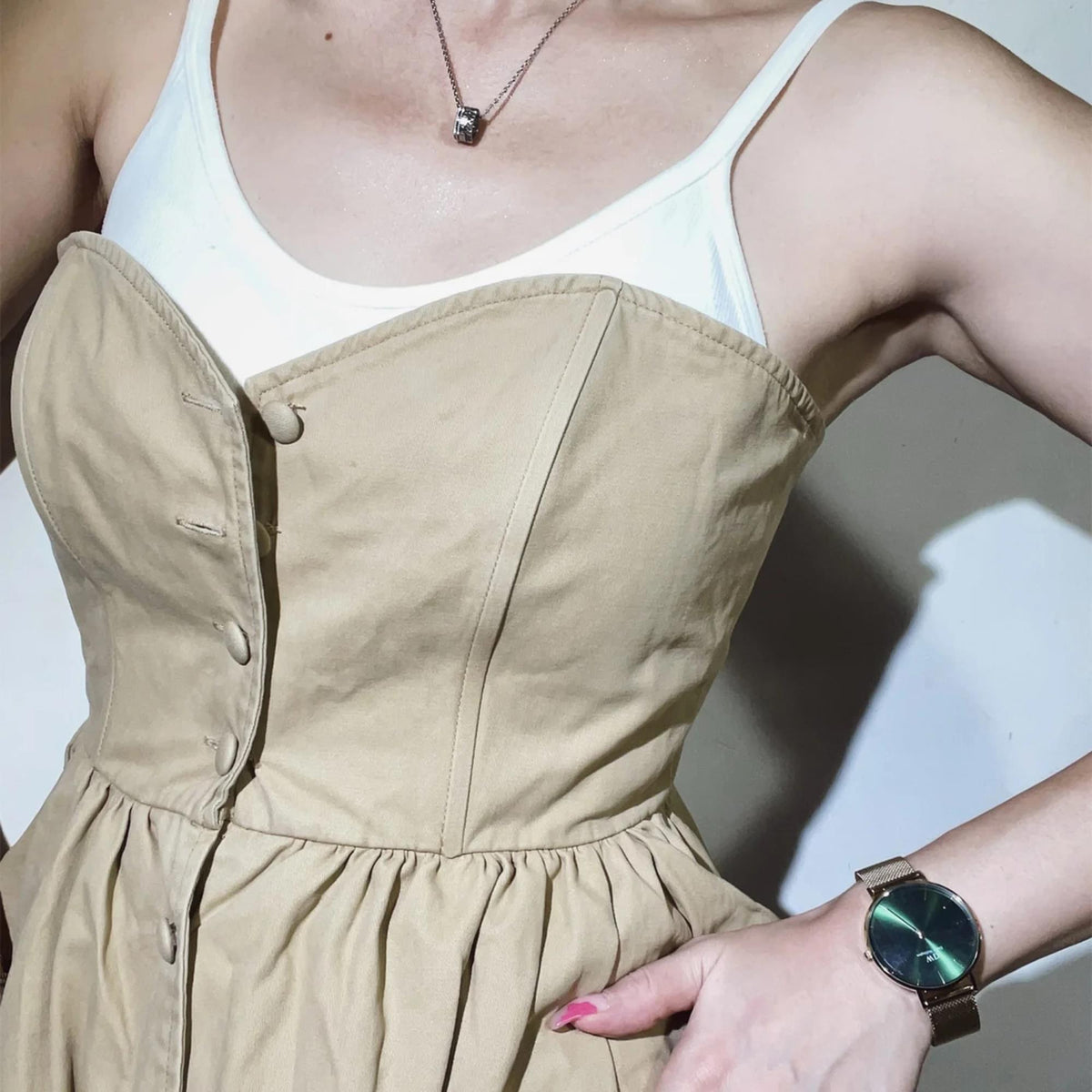 Ladies quartz watch on wrist with green dial and gold mesh bracelet