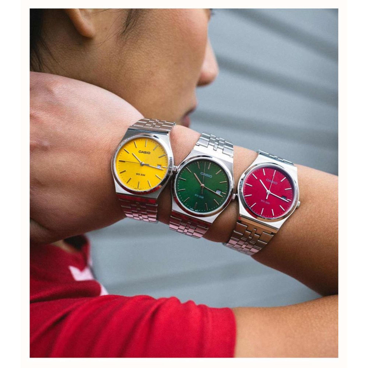 Yellow-dial men's steel strap watch on wrist, shown with two other watches