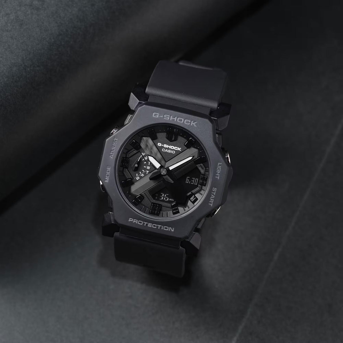 Casio G-Shock Core GA-2300-1AER angled studio shot resting on a dark textured background, emphasizing its octagonal bezel and rugged design