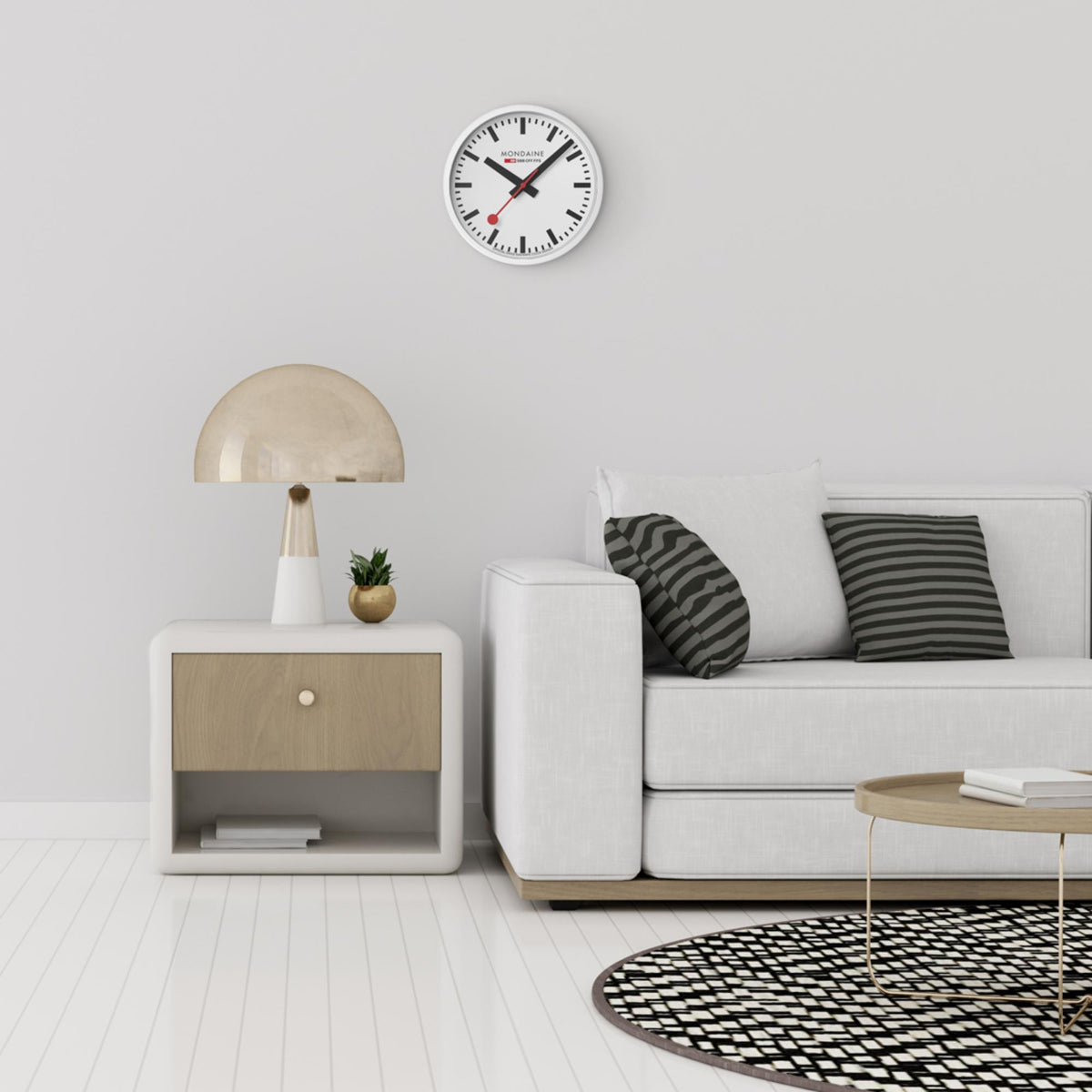 Mondaine quartz wall clock A990.CLOCK.10SBB styled above living room side table setup.