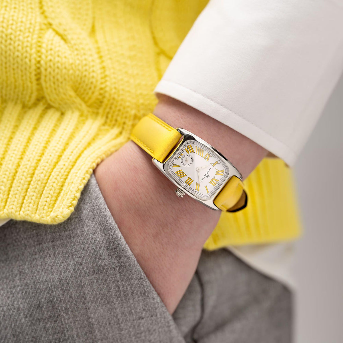 Ladies quartz watch on wrist, silver case, white dial, Roman numerals, yellow leather strap