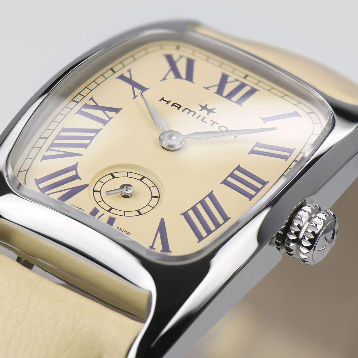 Close-up of beige dial ladies quartz watch with Roman numerals, silver case and crown
