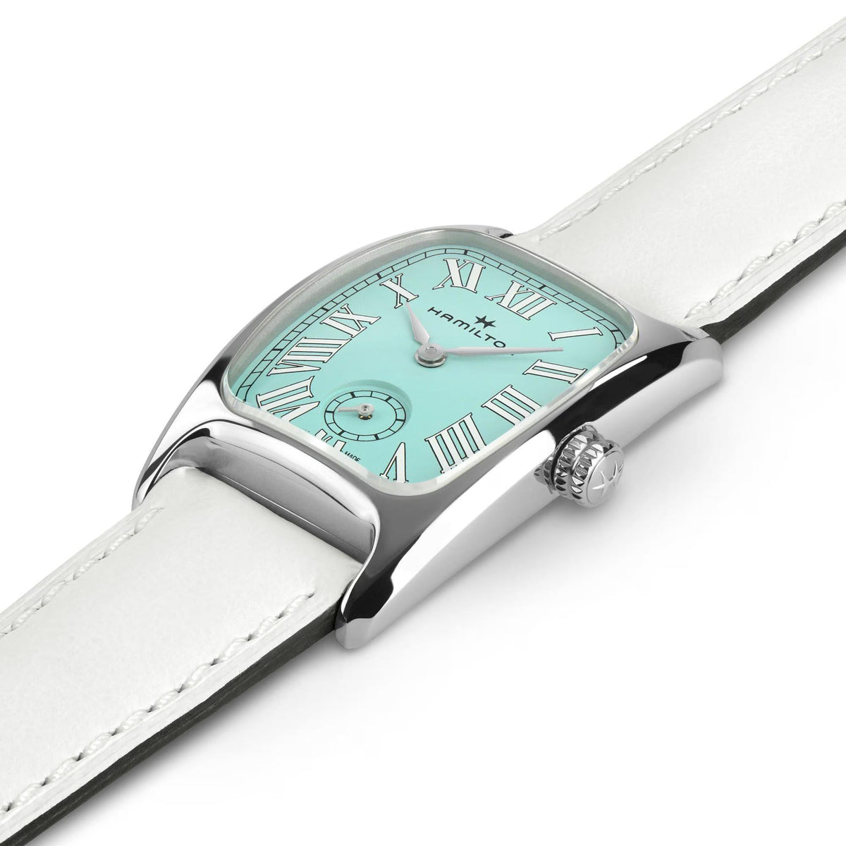 Close-up of ladies watch case with crown and white leather strap, green dial