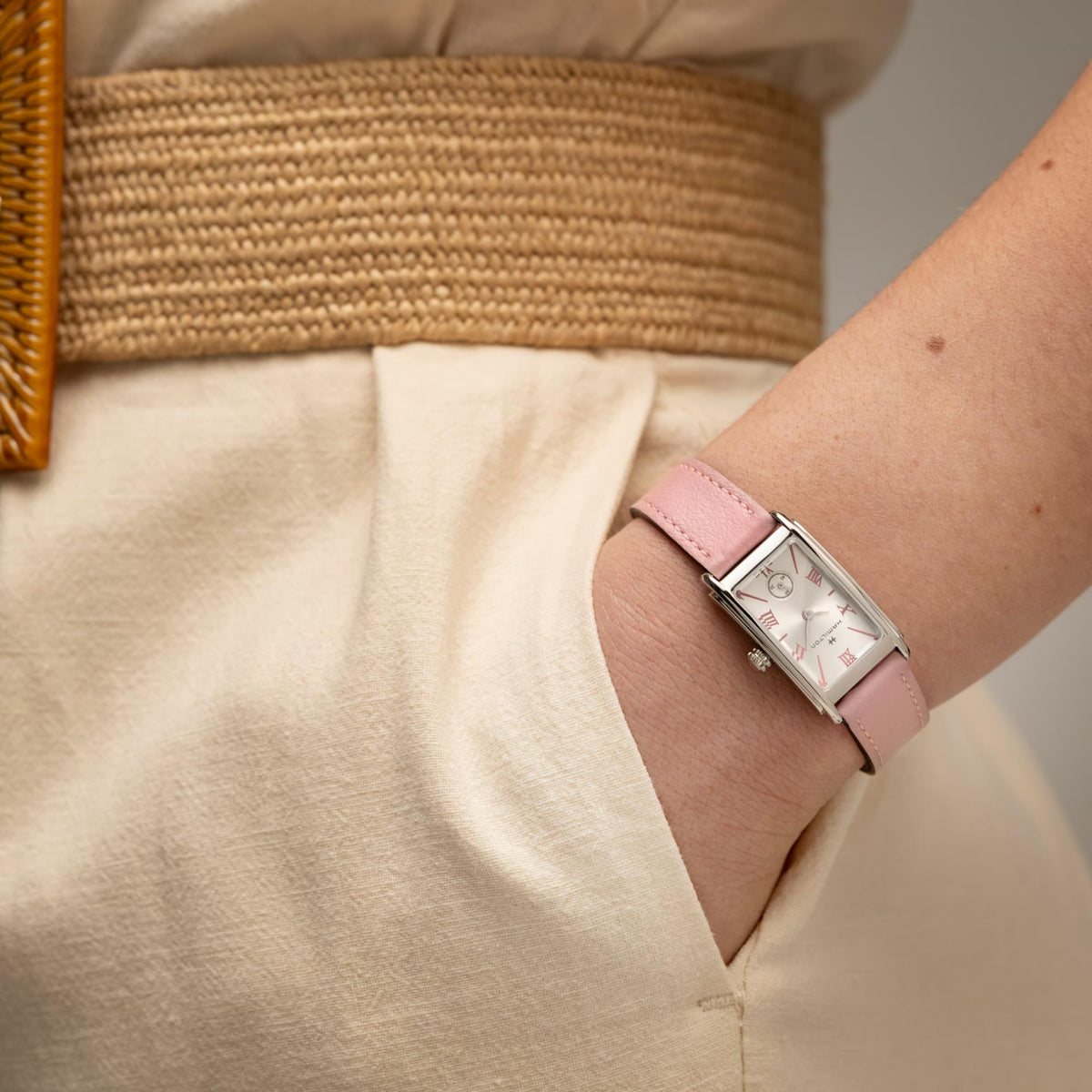 Ladies quartz watch on wrist with pink leather strap and silver case, white Roman numeral dial