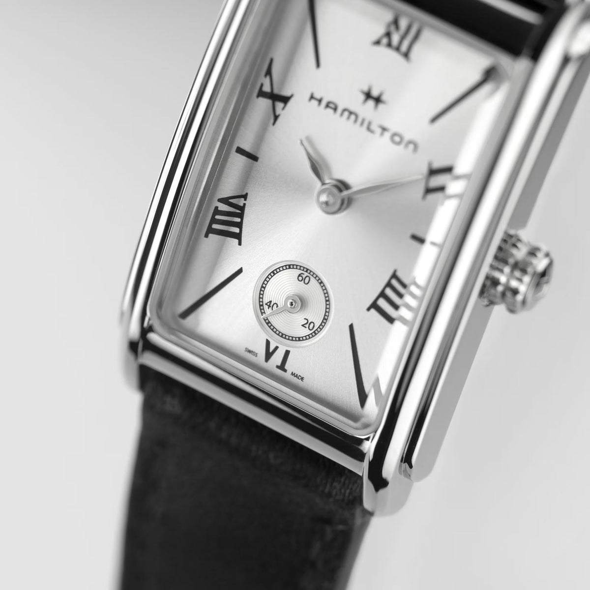 Ladies quartz watch dial close-up with roman numerals, subdial, and black leather strap.