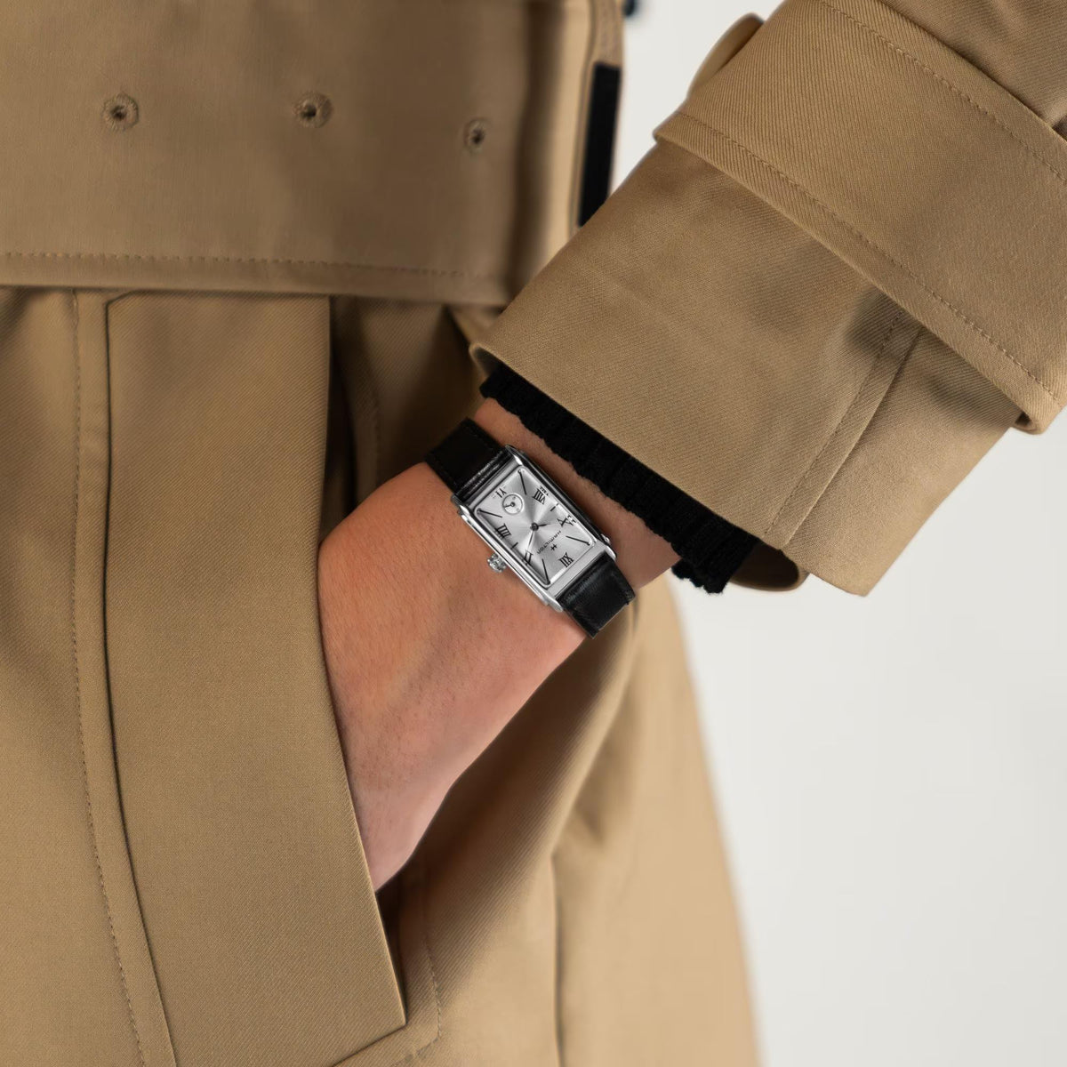 Ladies quartz watch worn on a wrist with black leather strap and silver case.