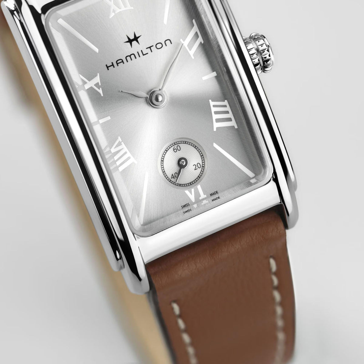 Close-up of silver dial with Roman numerals on brown leather quartz watch