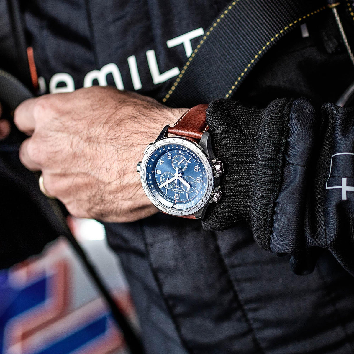 Men's quartz watch on wrist, blue dial with subdials, brown leather strap and steel case
