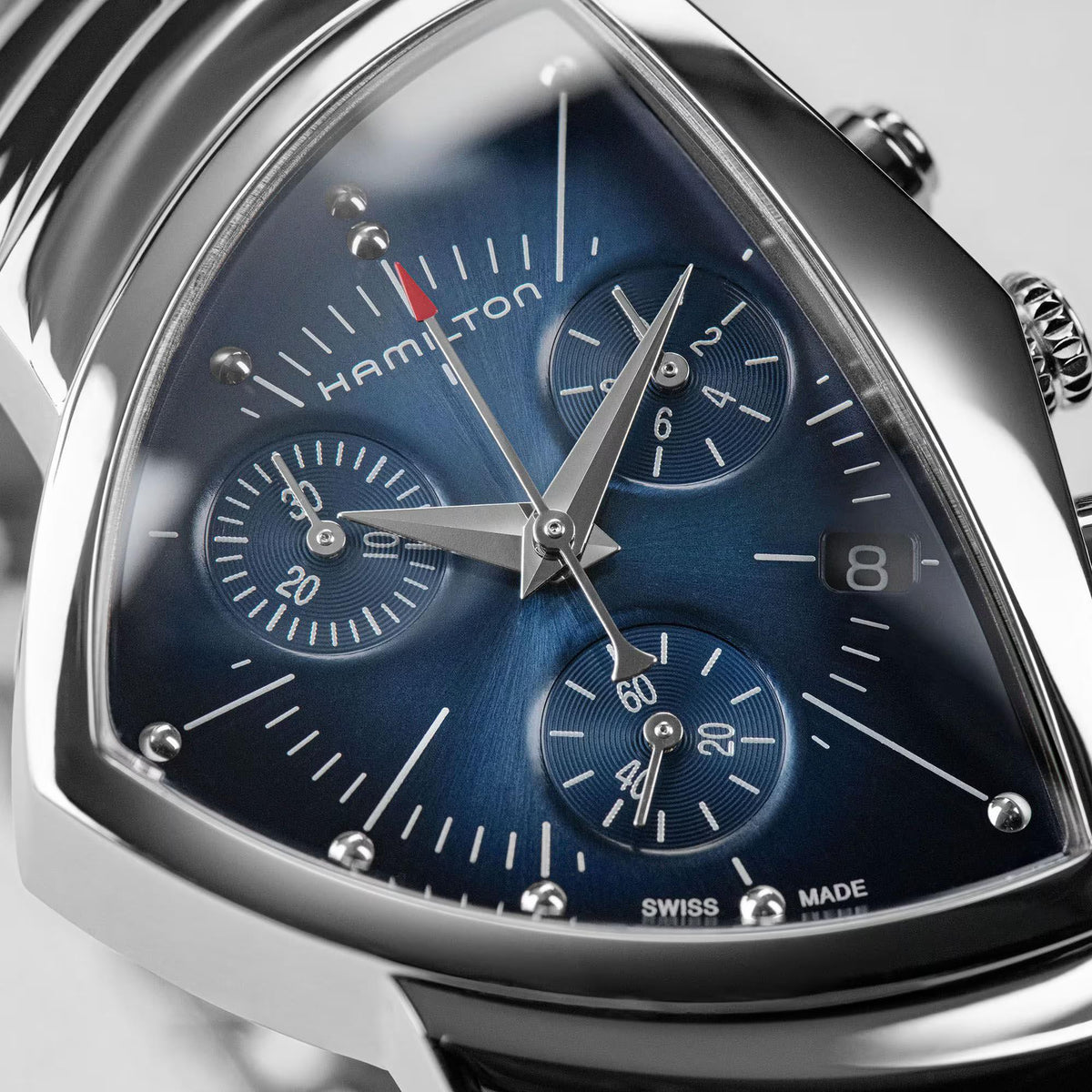 Blue dial chronograph quartz watch close-up with subdials and silver hands on steel case.