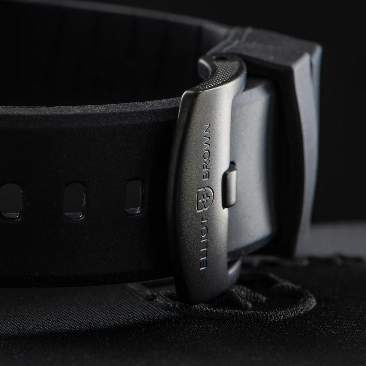 Men's quartz watch tang side with engraved branding on black rubber strap