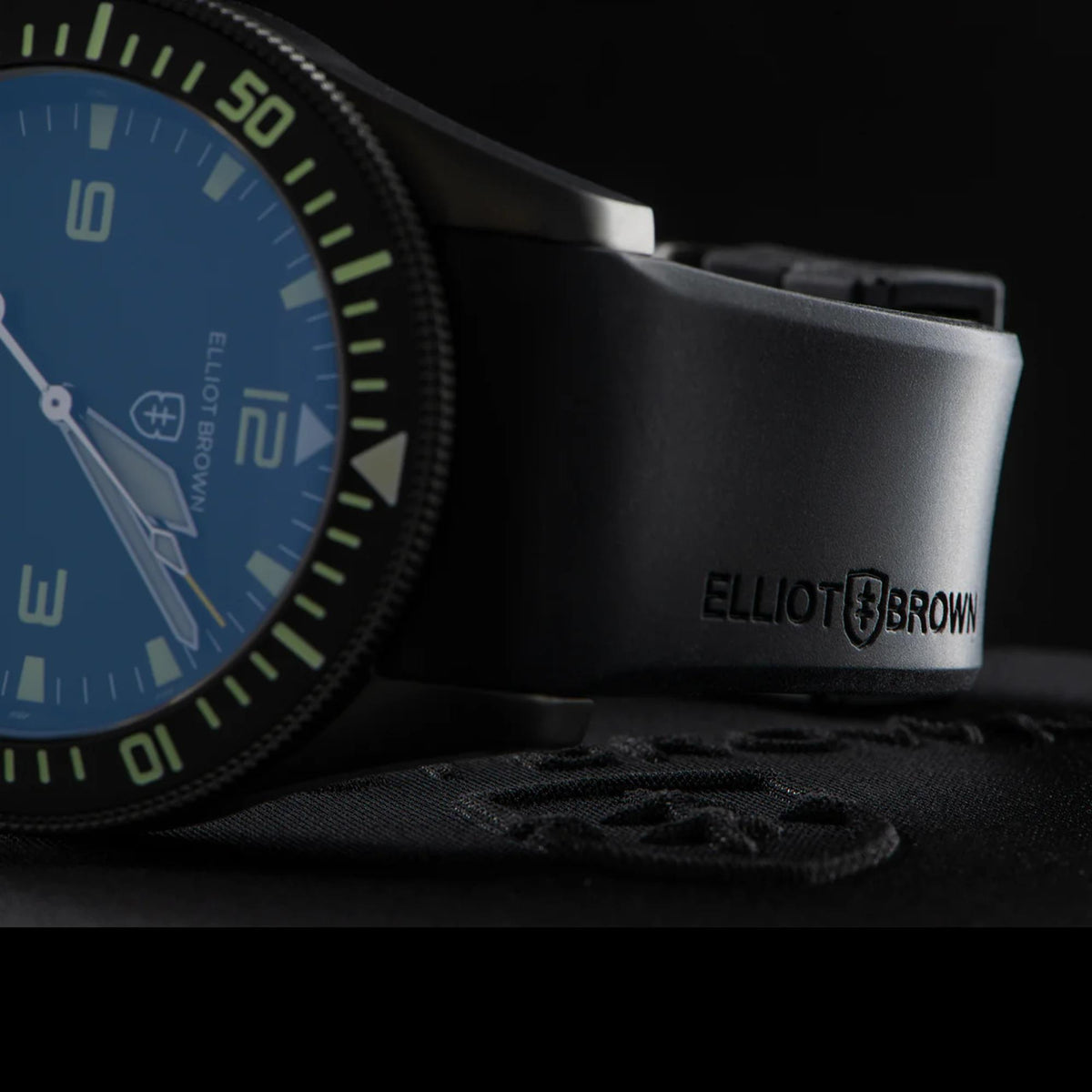 Men's quartz watch close-up with black bezel, blue dial, and black rubber band