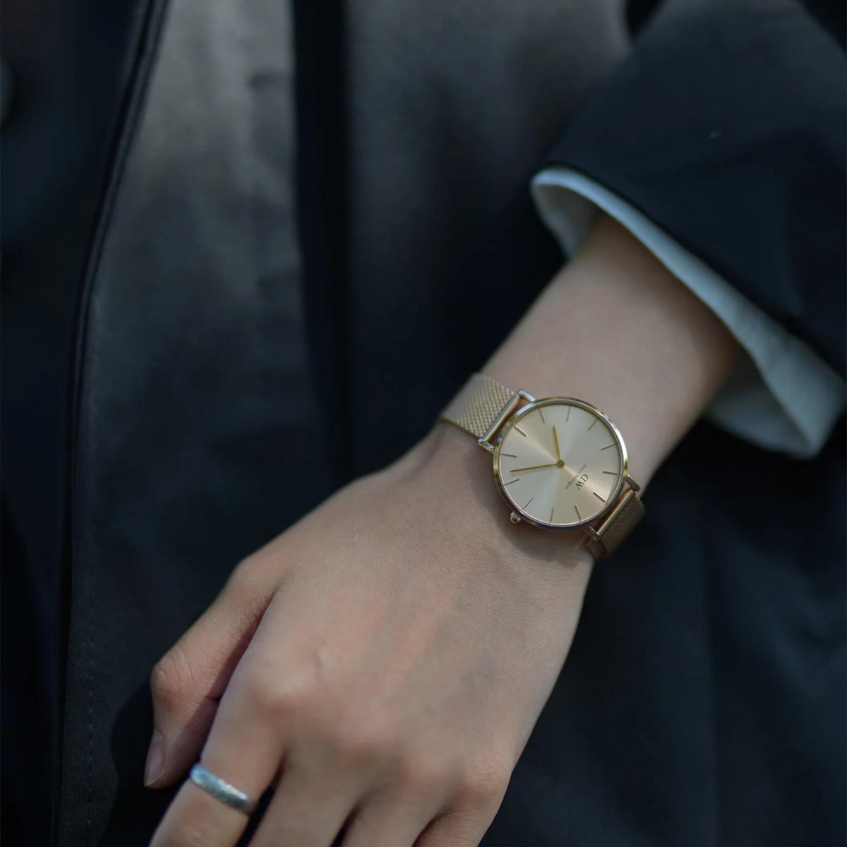 Gold-tone ladies quartz watch with light dial and mesh bracelet on wrist