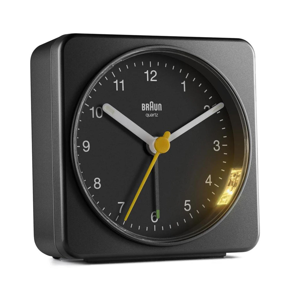 Black Braun quartz alarm clock with yellow hour/minute hands and glowing dial markers