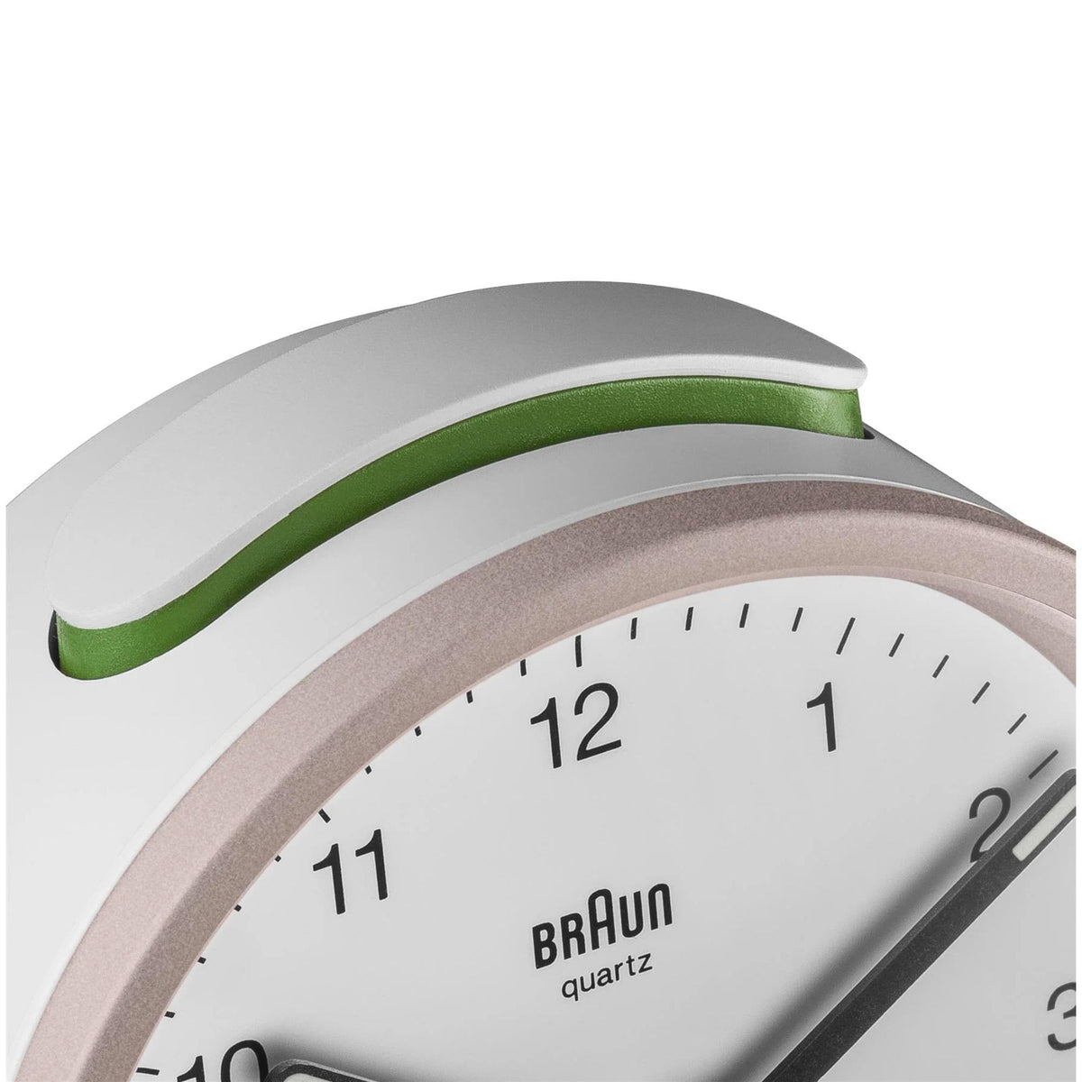 Braun quartz alarm clock top edge detail with green accent and rose-toned bezel