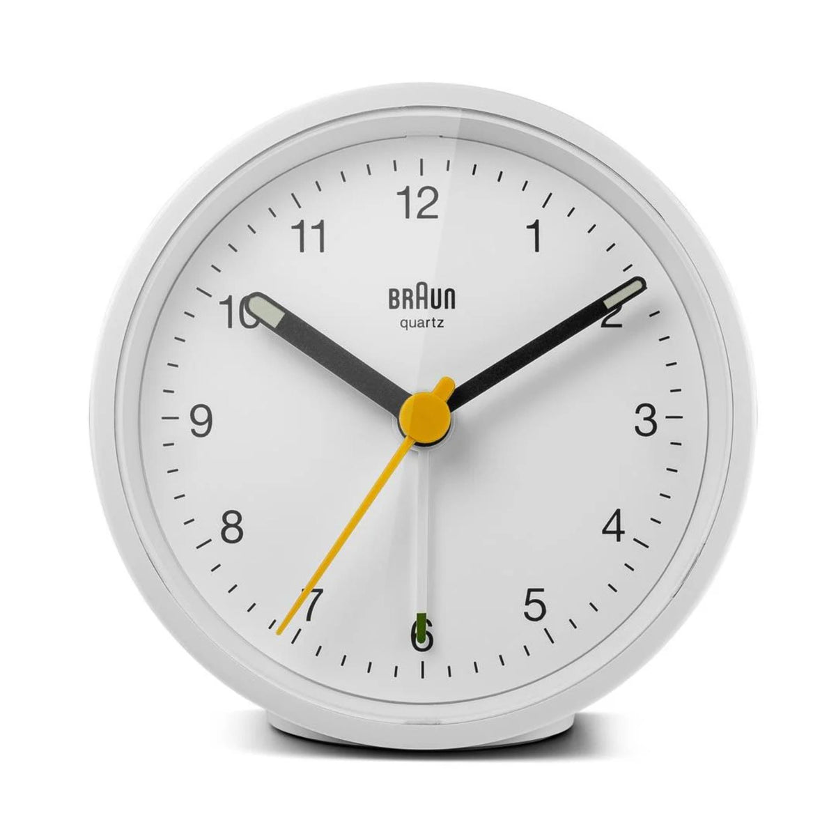 White round Braun quartz alarm clock front view, black dial with yellow hands and green marks