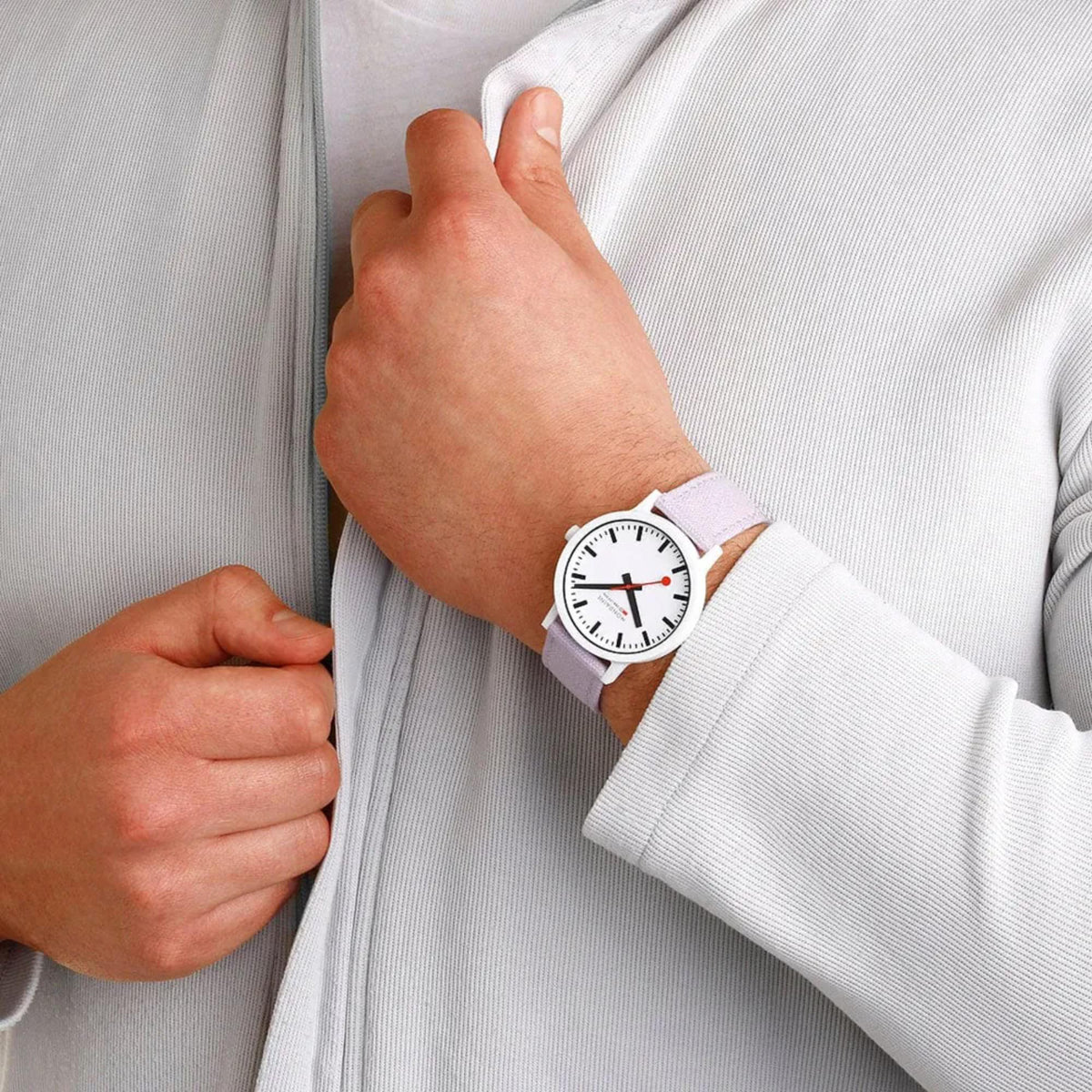 Men's quartz watch on wrist with white dial and light purple textile strap