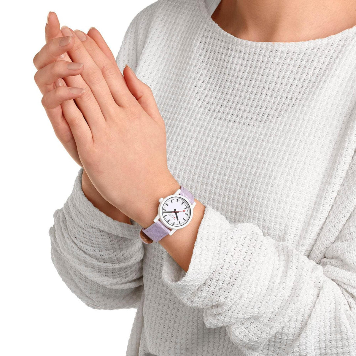 Women’s quartz watch on wrist with lavender textile strap and white dial