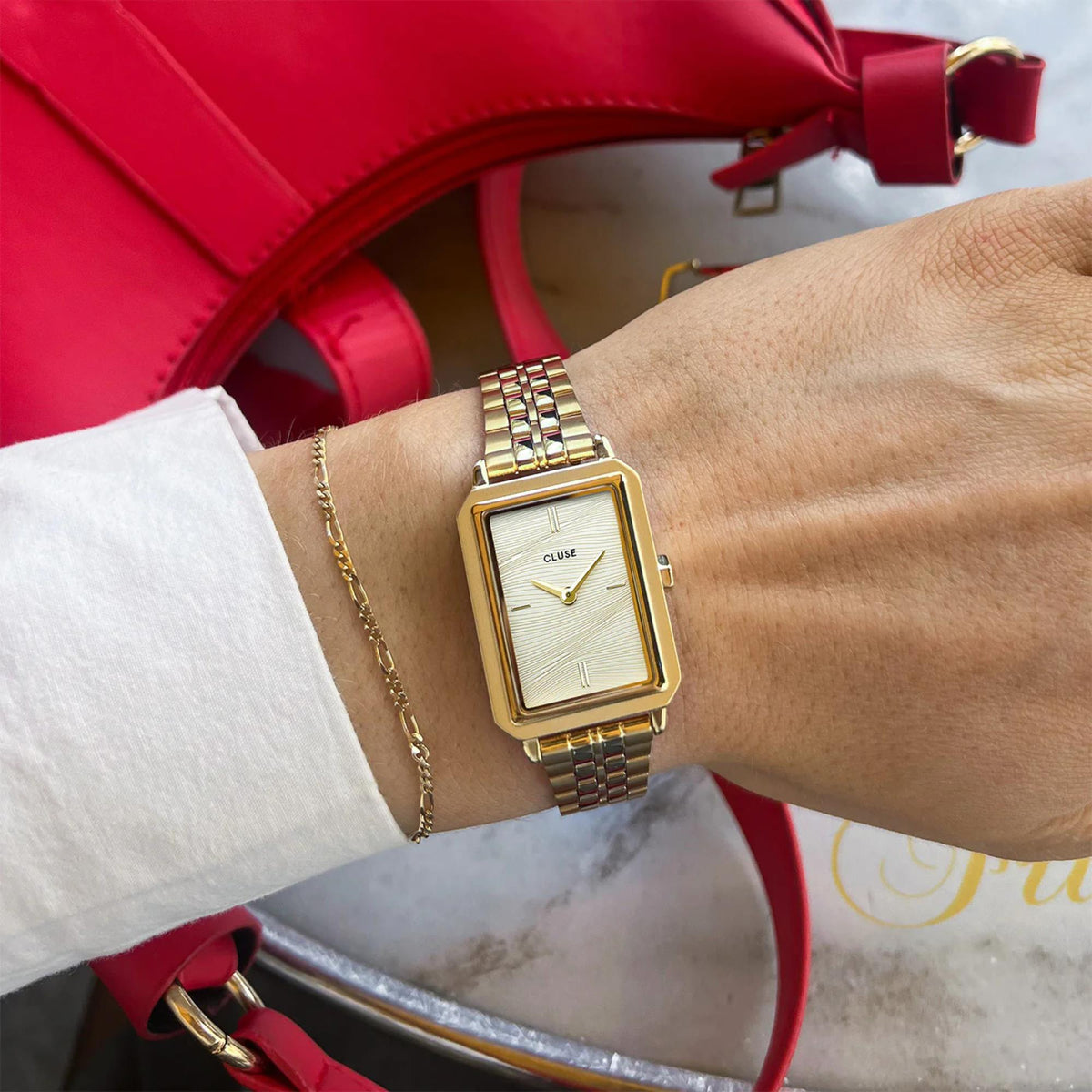 Gold-tone women’s square wristwatch with light textured dial and metal link bracelet
