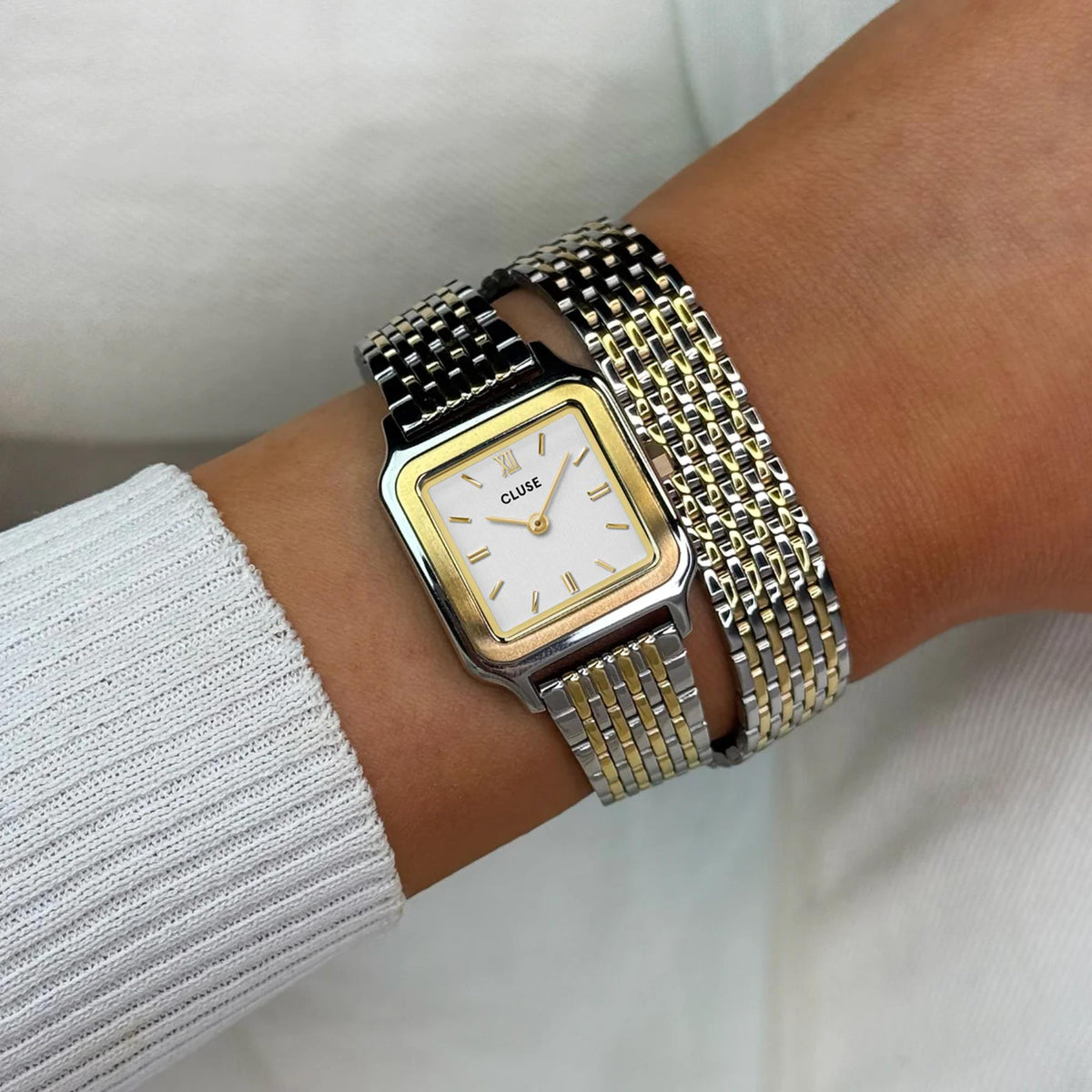 CLUSE petite quartz watch on wrist, white dial, square case, two-tone steel mesh band