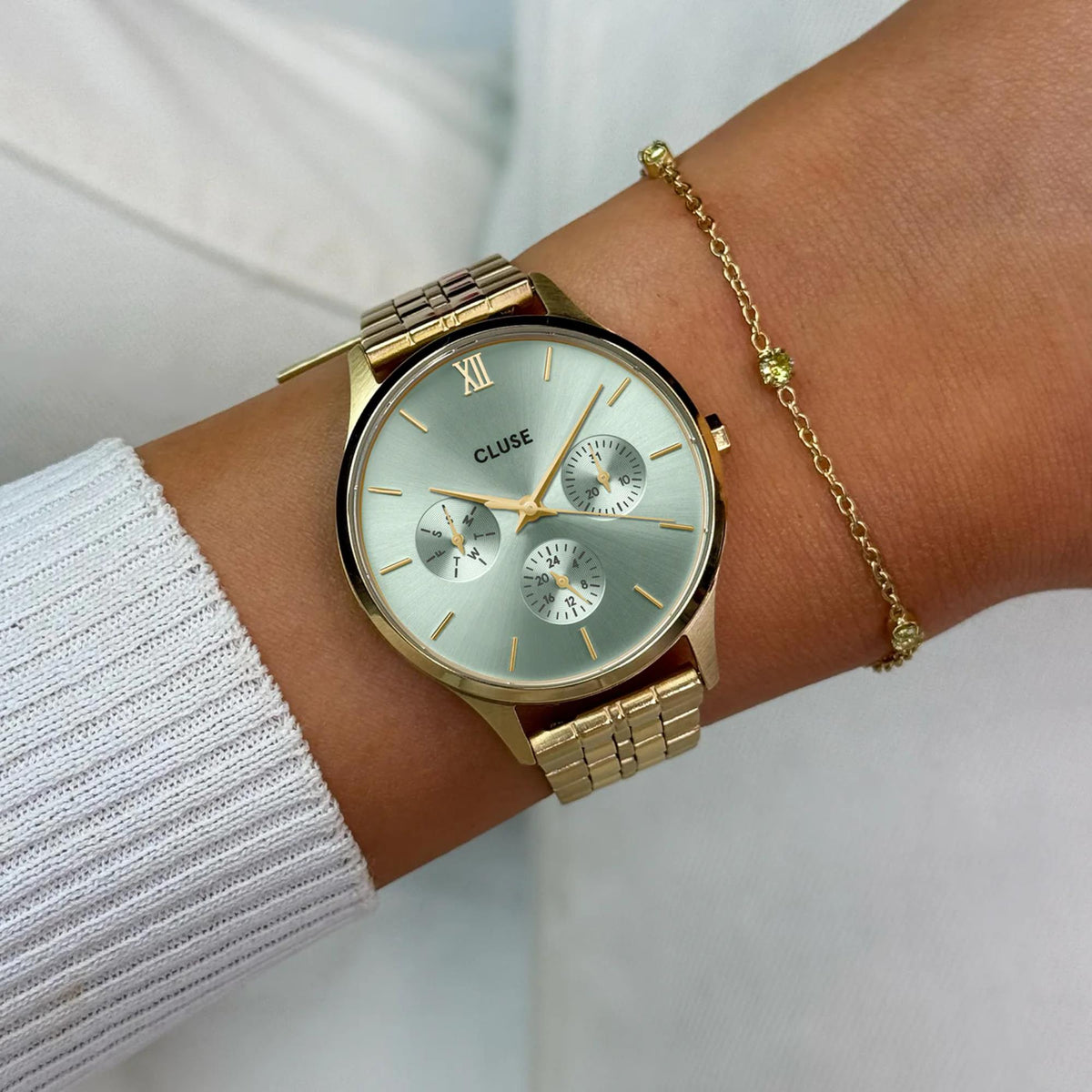 CLUSE Minuit watch on wrist, green chronograph dial with gold-tone steel band