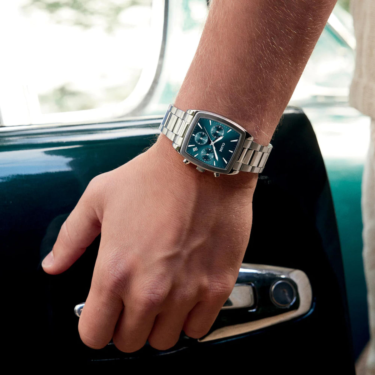 Men's steel chronograph watch with blue dial on wrist in car