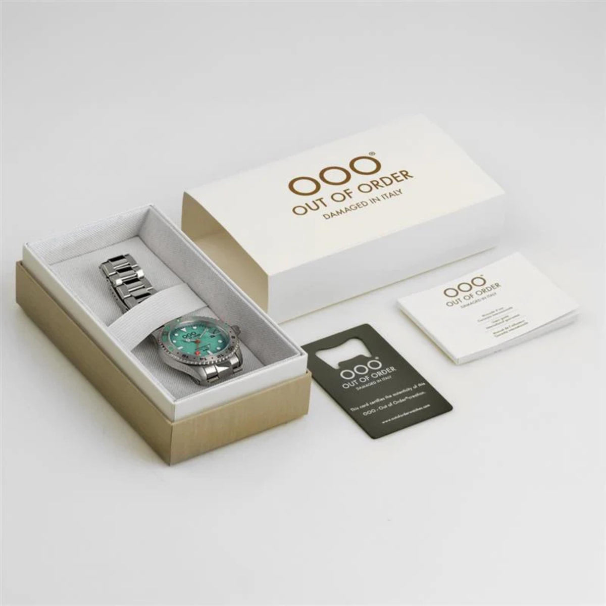 Men's GMT watch in open box with matching green dial and instruction cards.