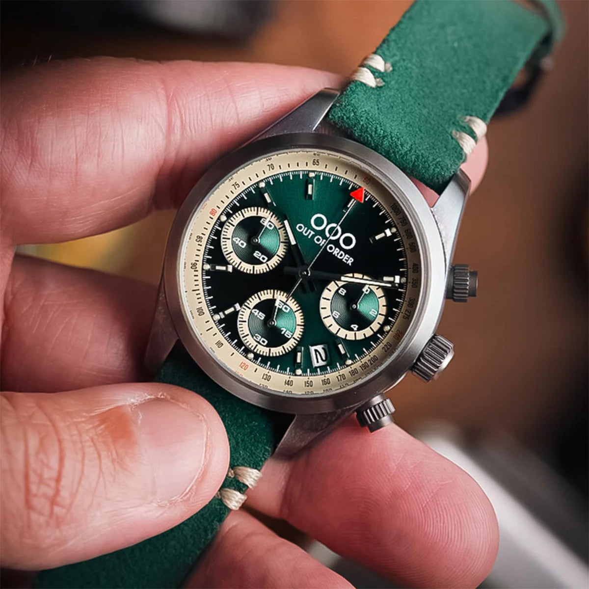 Men's sporty quartz chronograph watch with green dial and green leather strap close-up.