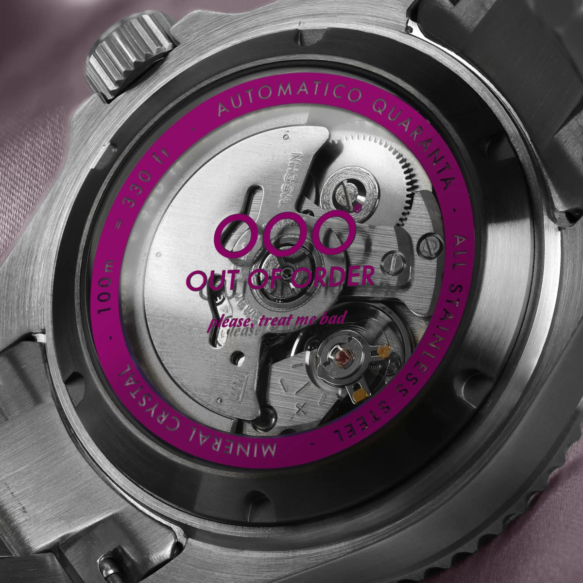 Stainless steel watch caseback with magenta ring and engraved automatic parts.