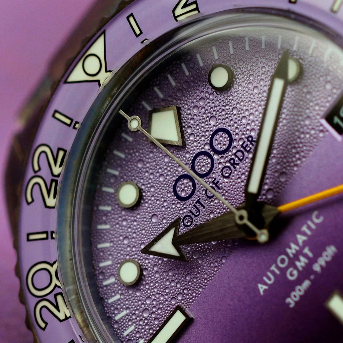 Close-up of purple dial with luminous markers and automatic GMT hands