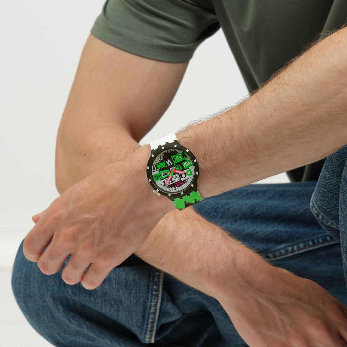 Silicone strap wristwatch with black bezel and white strap, colorful graphic dial on wrist