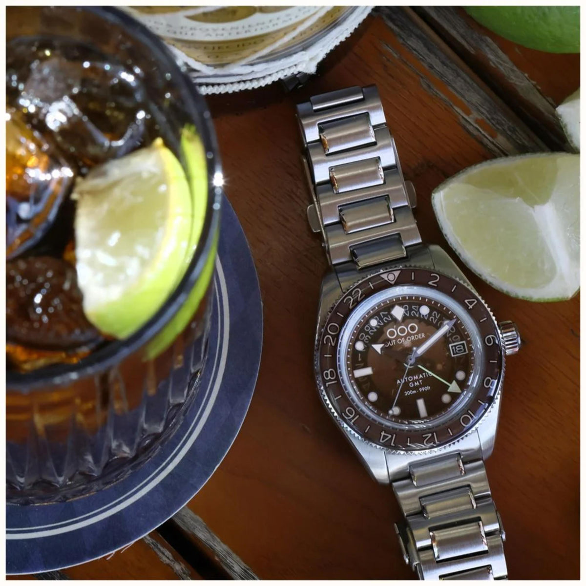 Men's automatic steel watch with dark brown dial and linked bracelet on wrist