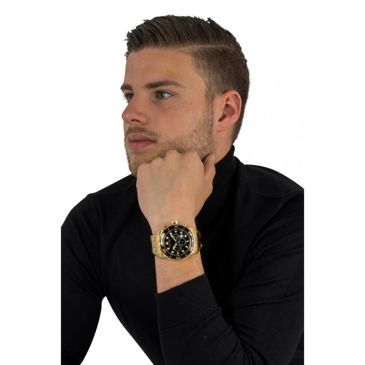 Men's diver watch on wrist, gold-tone case and black dial with metal bracelet