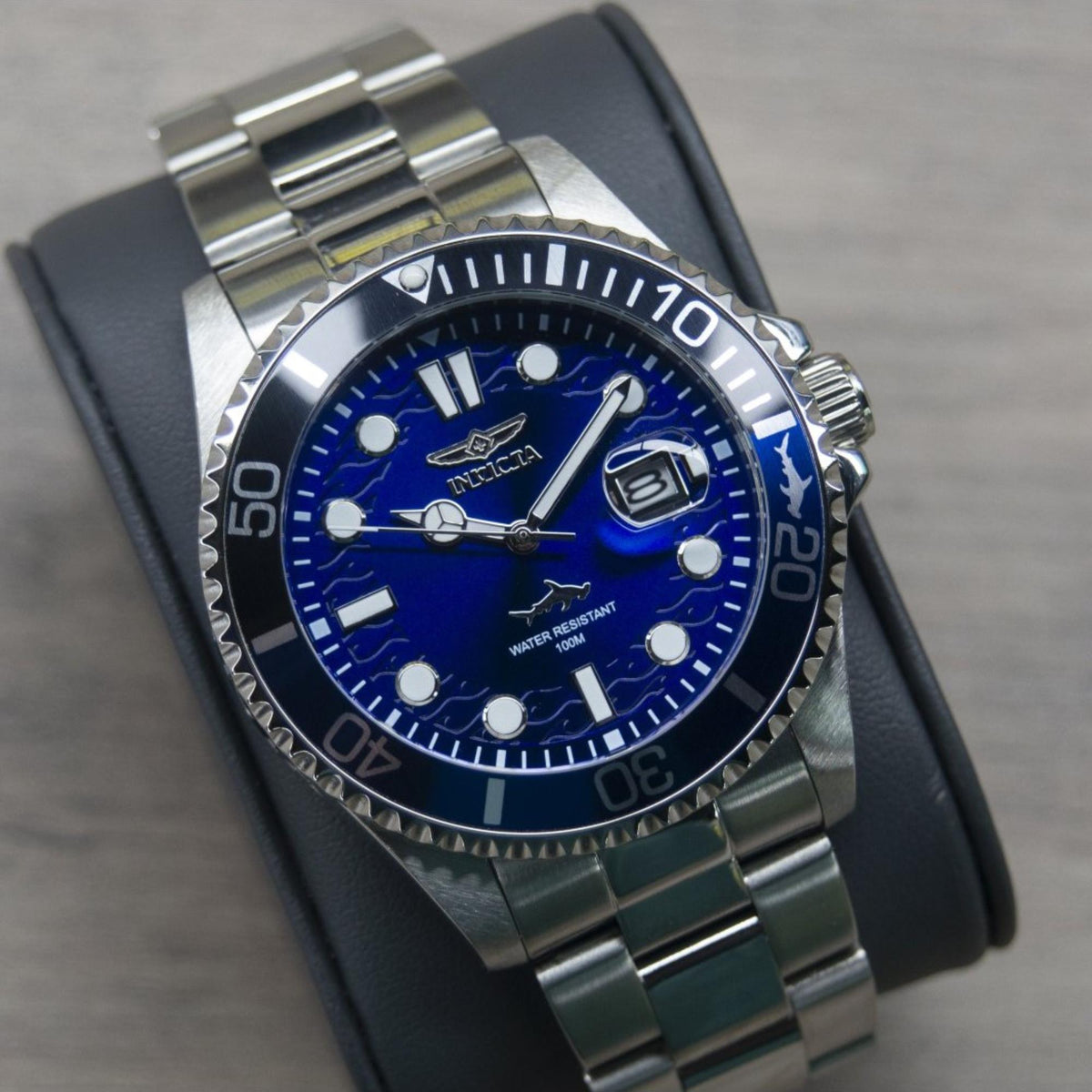 Blue dial dive watch with steel case, rotating bezel, date window, on dark strap