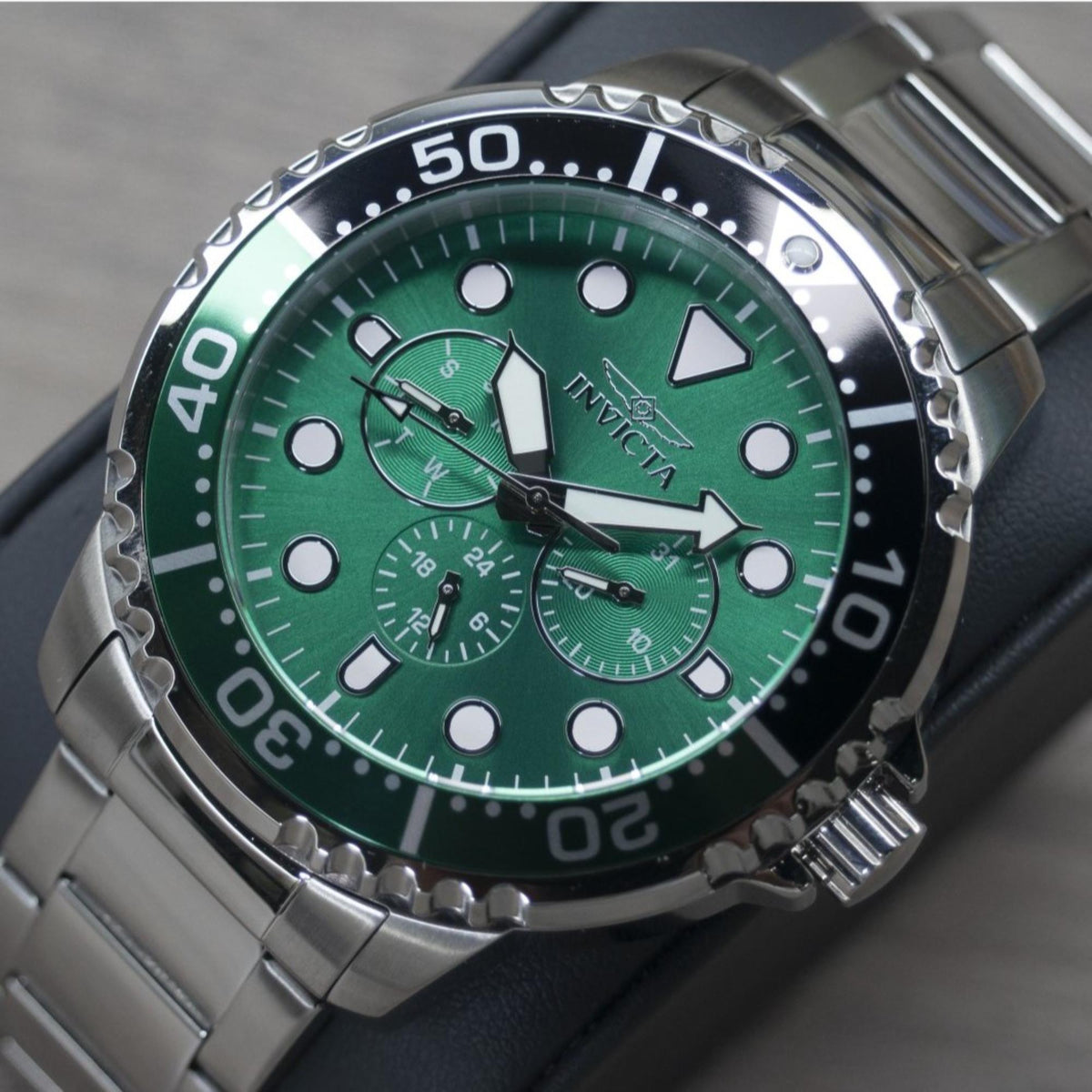 Men's Invicta pro diver watch, green dial with subdials, steel case, black bezel, angled view