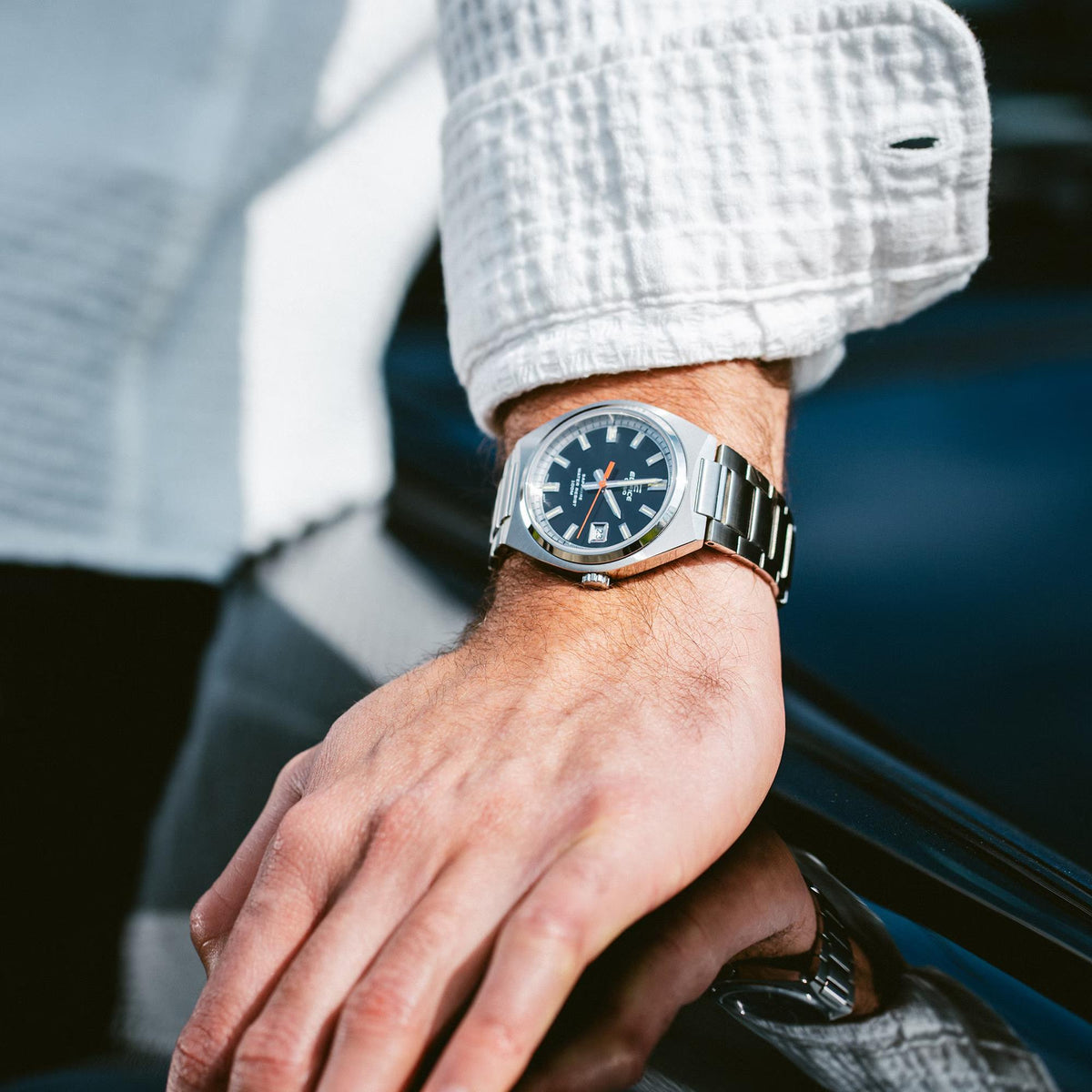 Detailed wrist shot of the Casio Edifice EFB-109D-1AVEF black dial quartz watch paired with a white long-sleeve top
