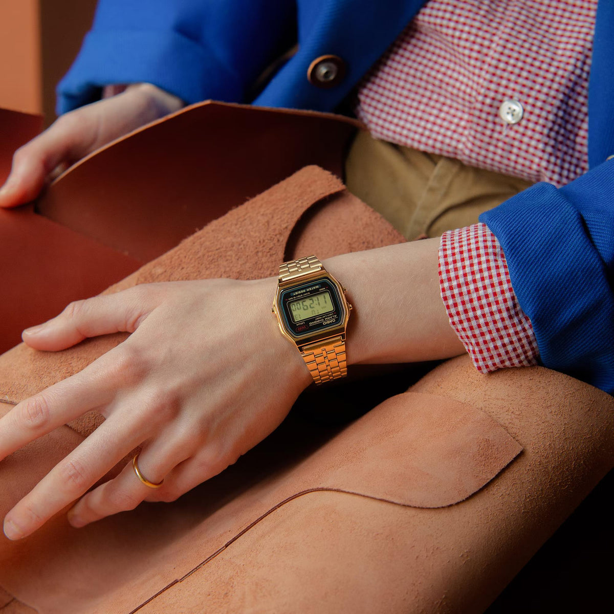 Casio digital quartz watch on wrist with gold-tone mesh bracelet and LCD display