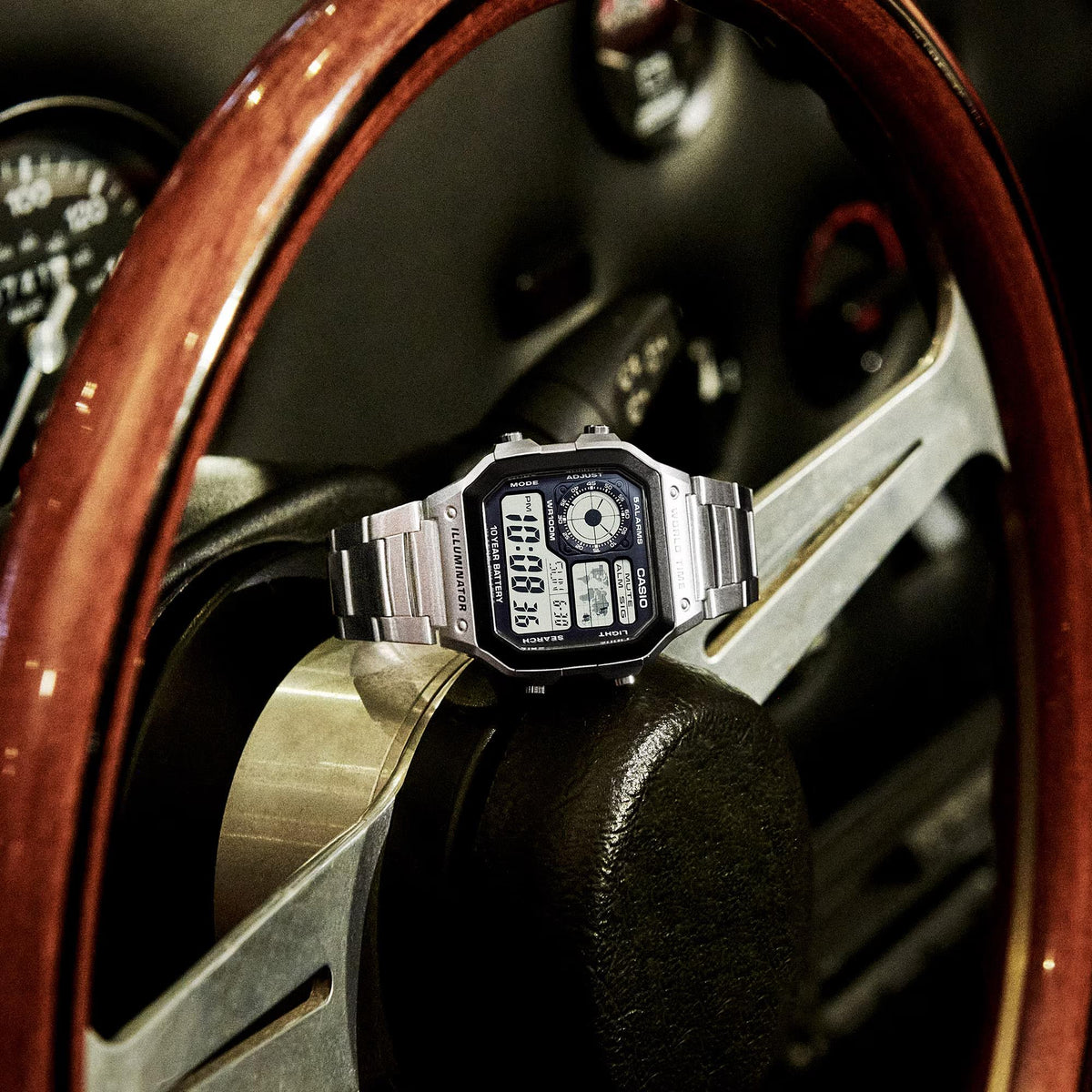 Men's digital world time wristwatch with steel bracelet and black display close-up.