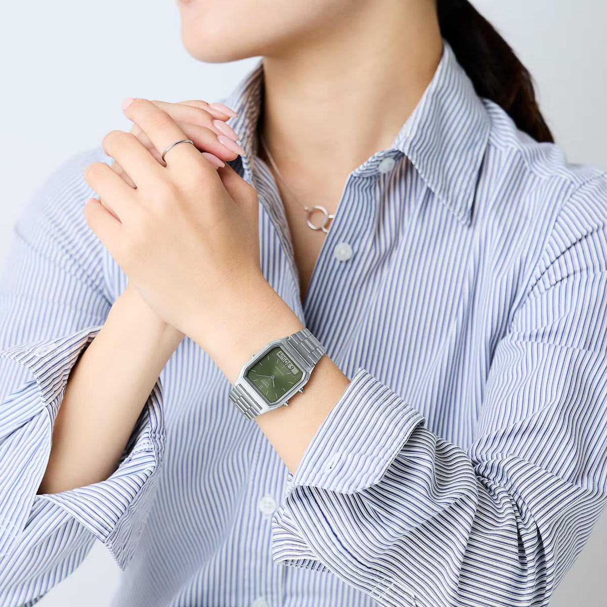 Green dial Casio quartz watch with stainless steel bracelet on a wrist