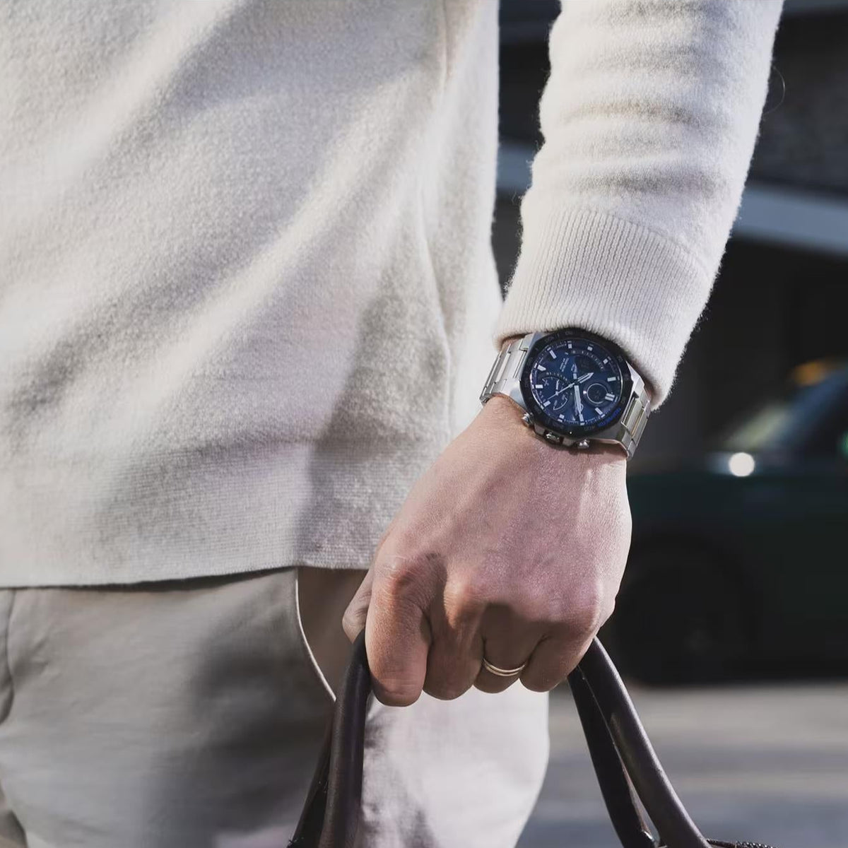 Men's solar-powered steel watch with blue dial and round bezel, on a wrist