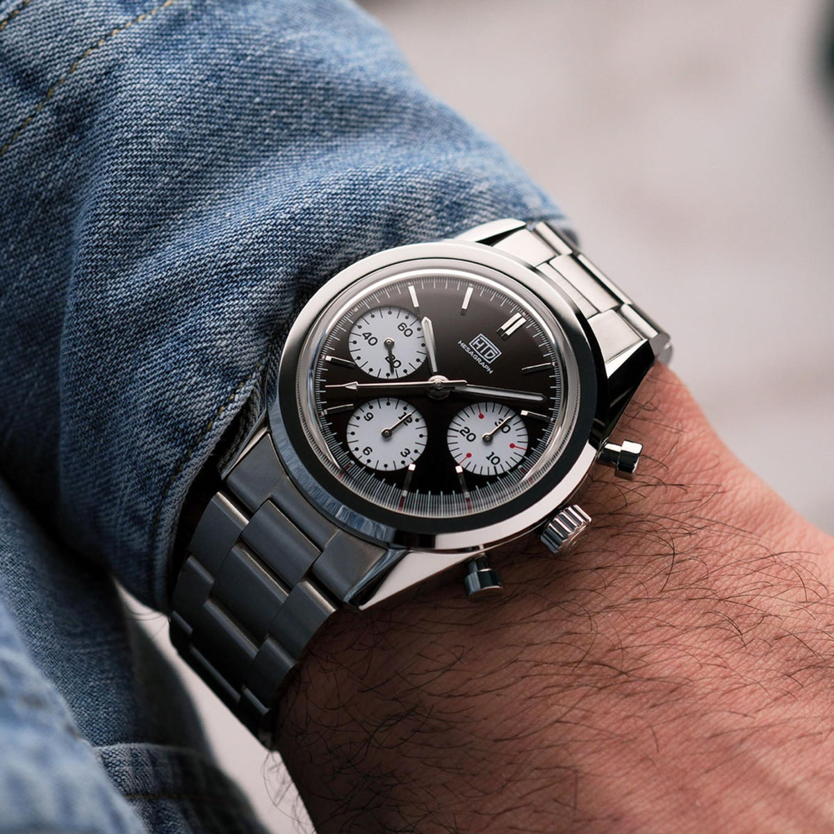 Men's chronograph watch with dark brown dial, steel bracelet, and three subdials
