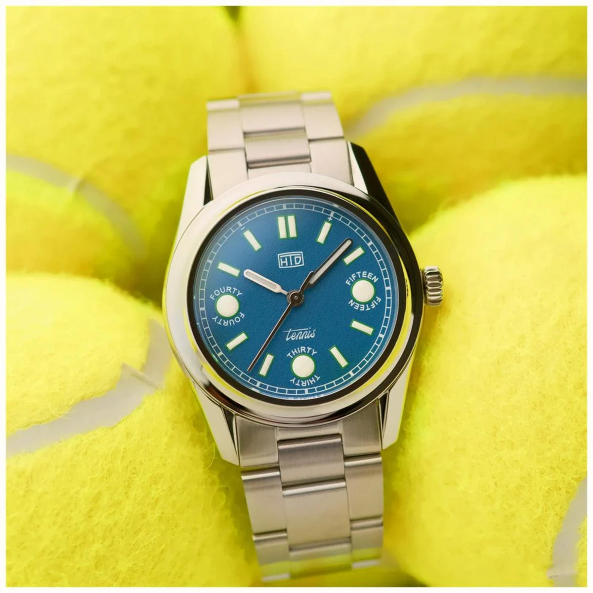 Stainless steel sports watch with blue dial and metal bracelet, round case close-up