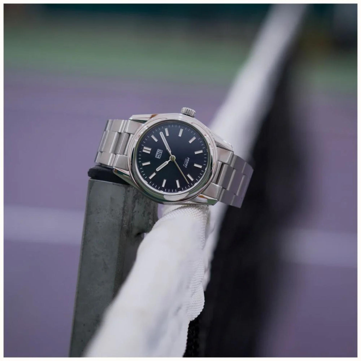Stainless steel sports watch with blue dial and crown detail on wrist
