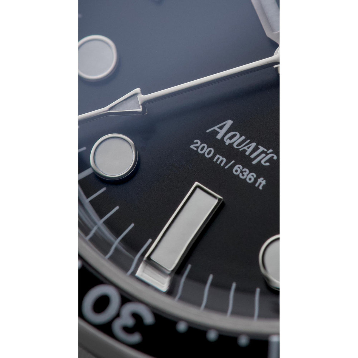 Black watch dial detail with silver hour markers and minute track