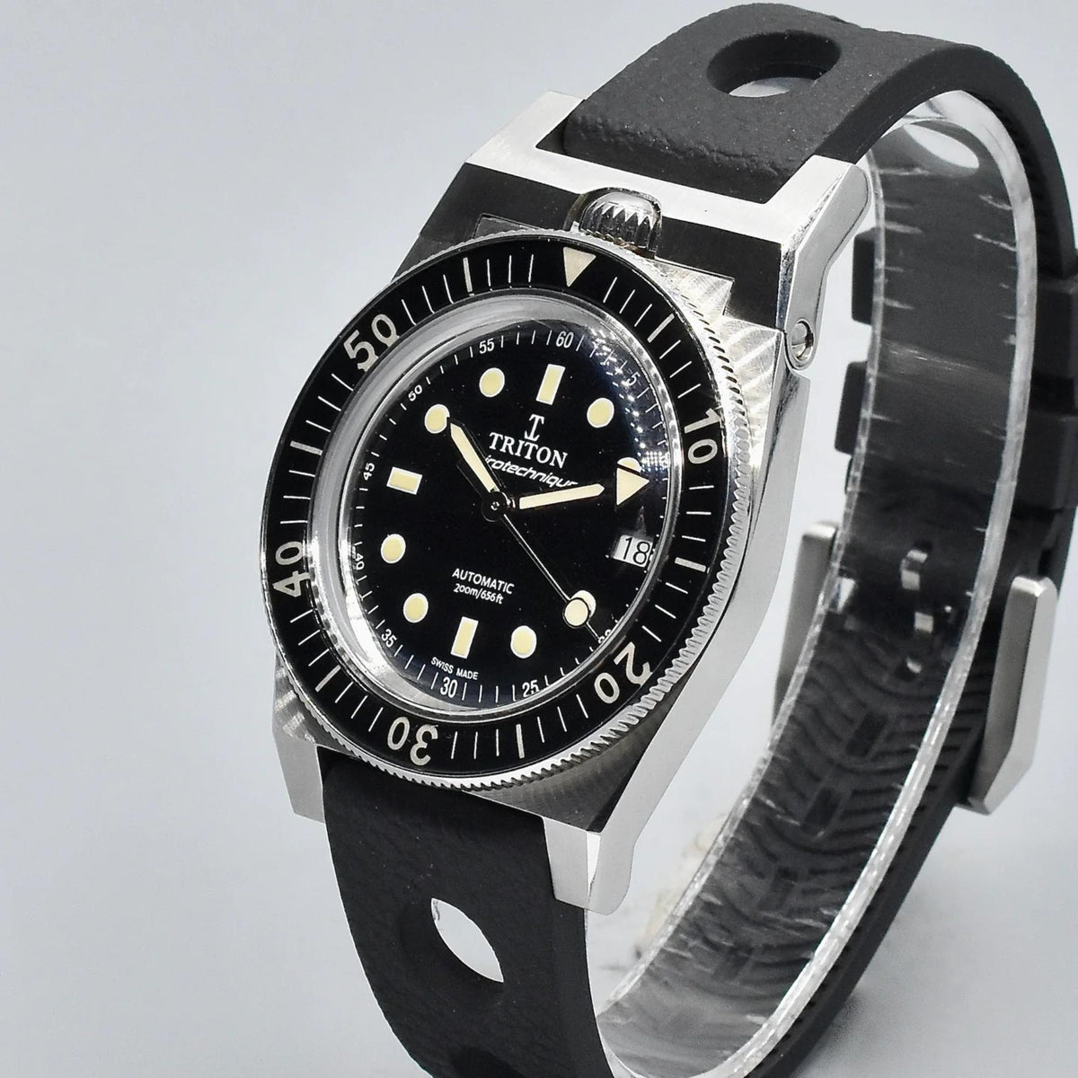 Men's black dial diver watch with steel case, black rubber strap, side profile