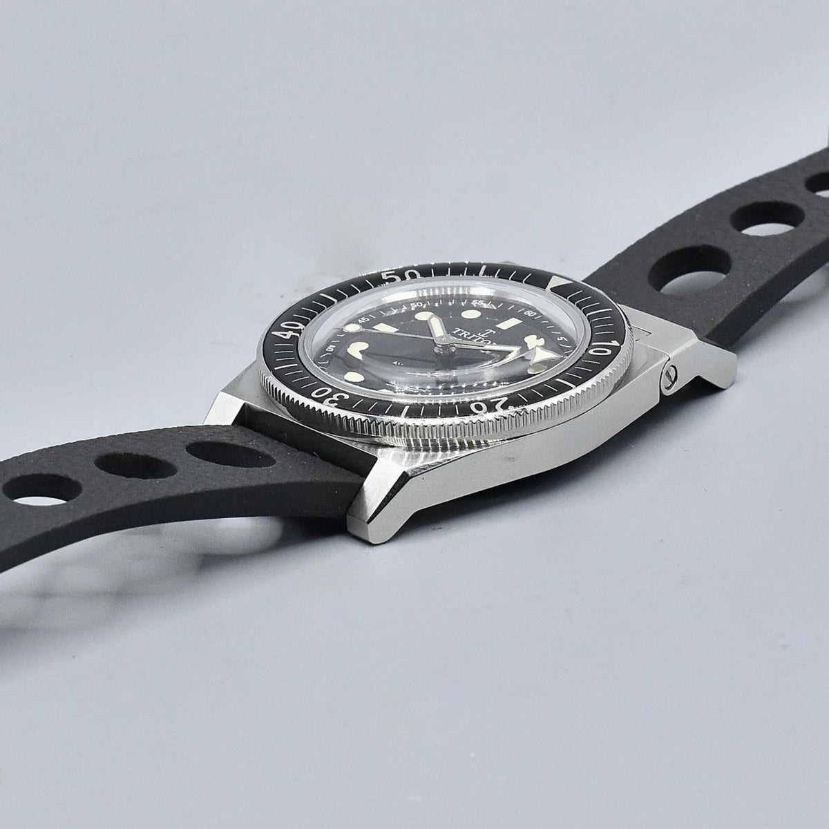 Men's black dial dive watch on black rubber strap, angled side view