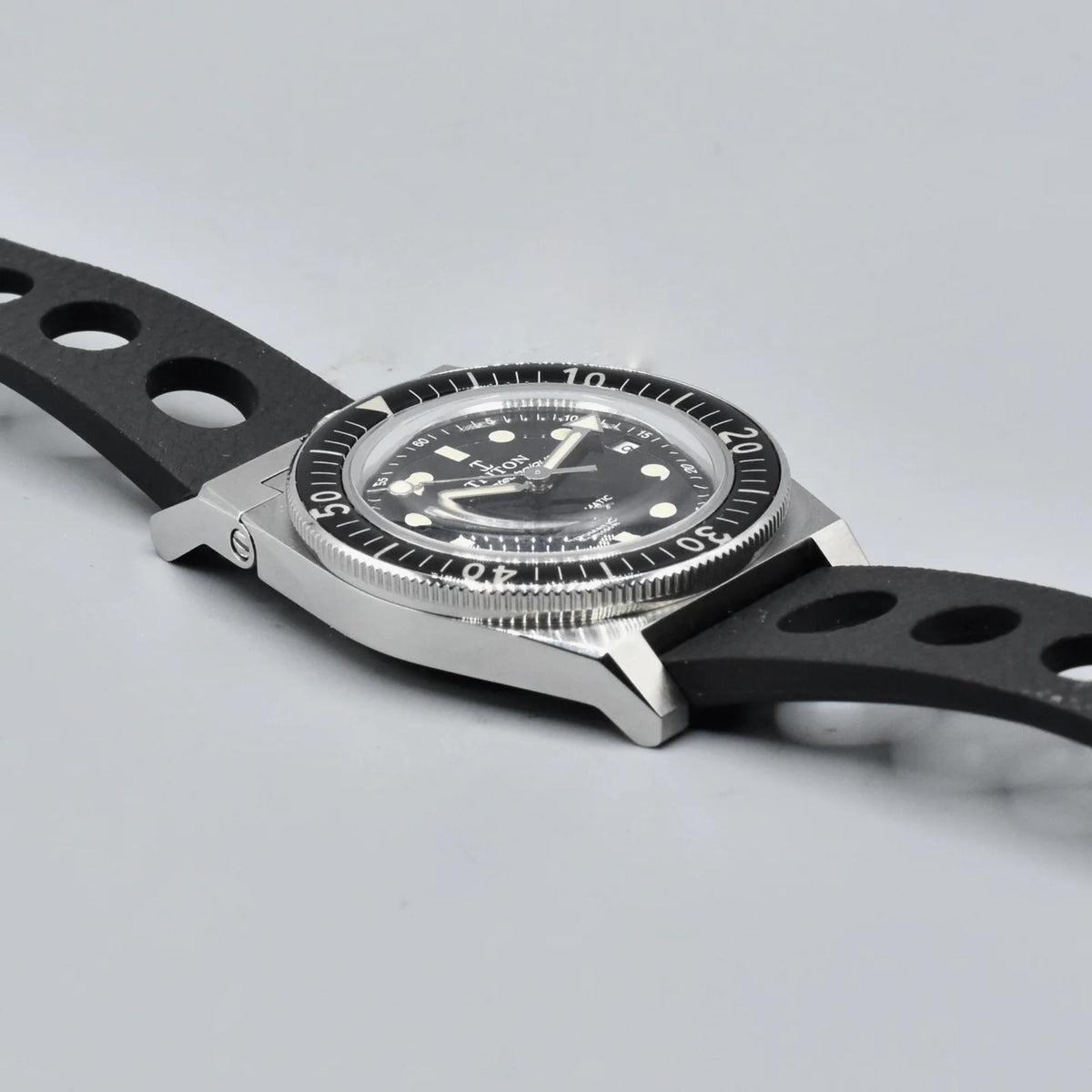 Men's black dial dive watch with ridged bezel and black rubber strap, close side