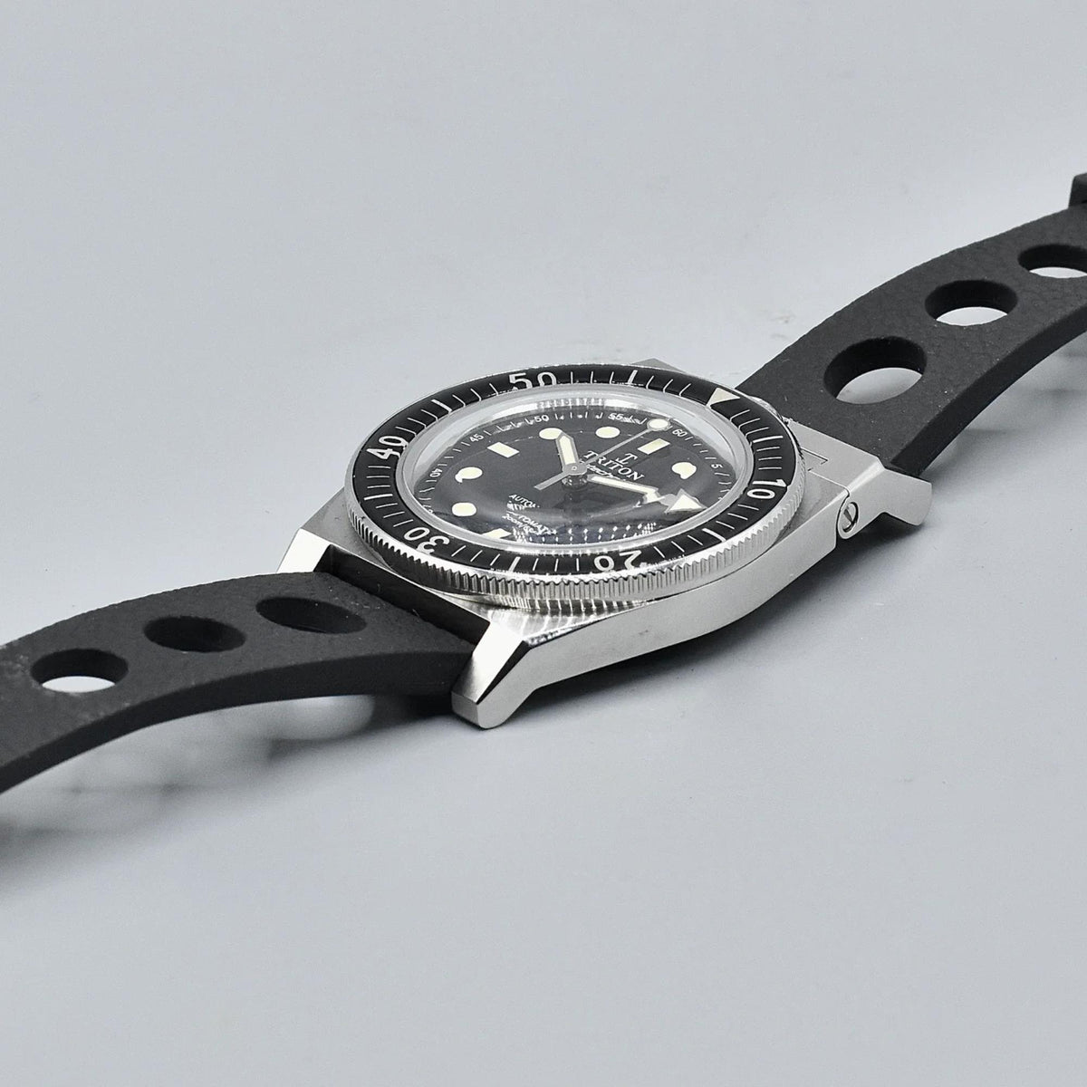 Men's black dial dive watch on black rubber strap, front three-quarter view